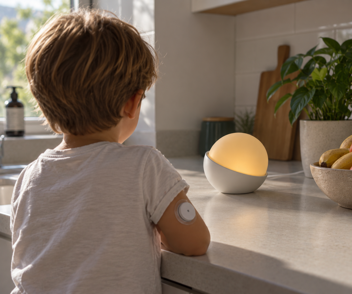 A child with a CGM sensor looking at the Glowcose lamp glowing softly on a kitchen counter